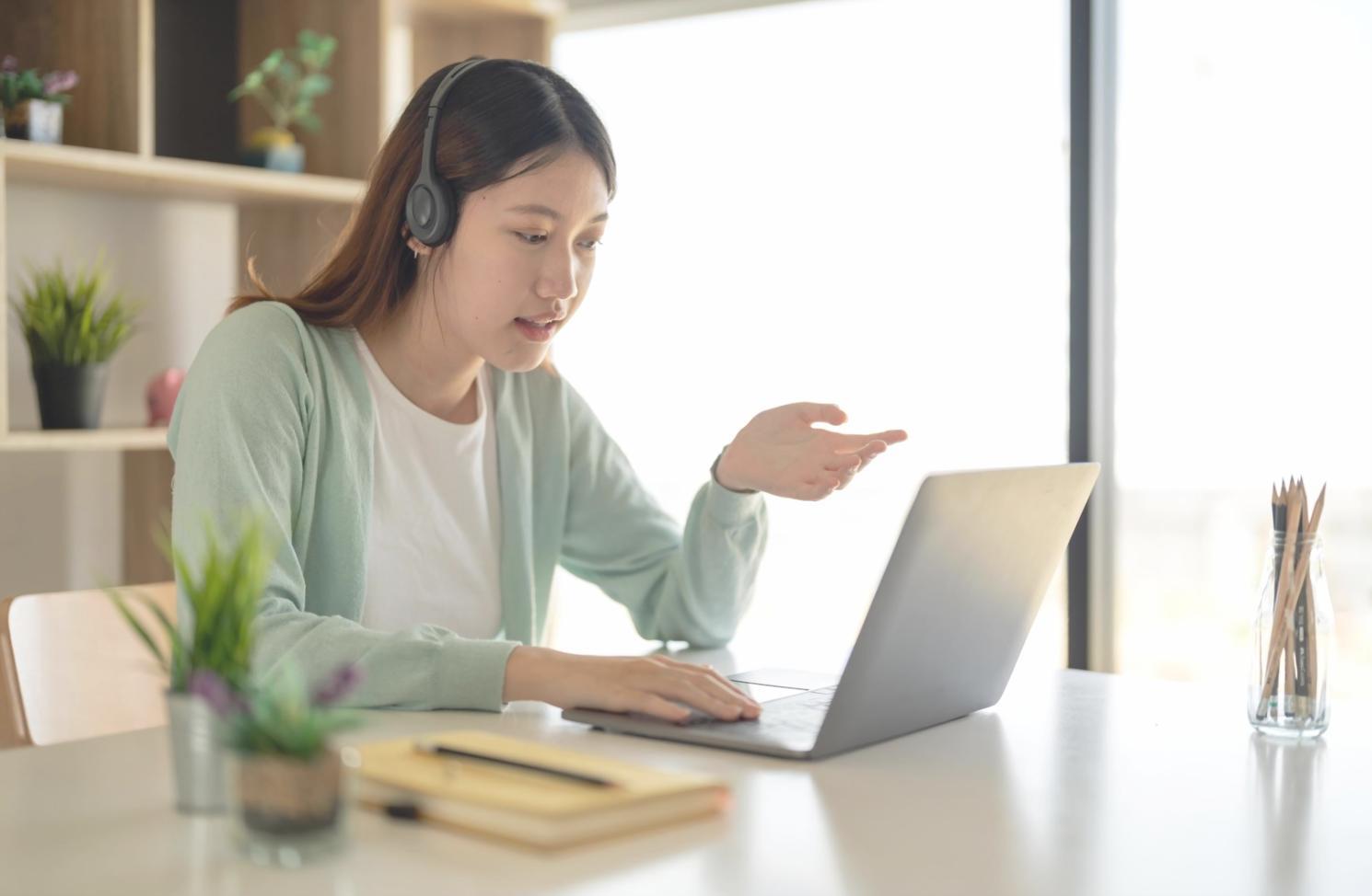 Žena plánující rodinný rozpočet u stolu s kalkulačkou a dokumenty